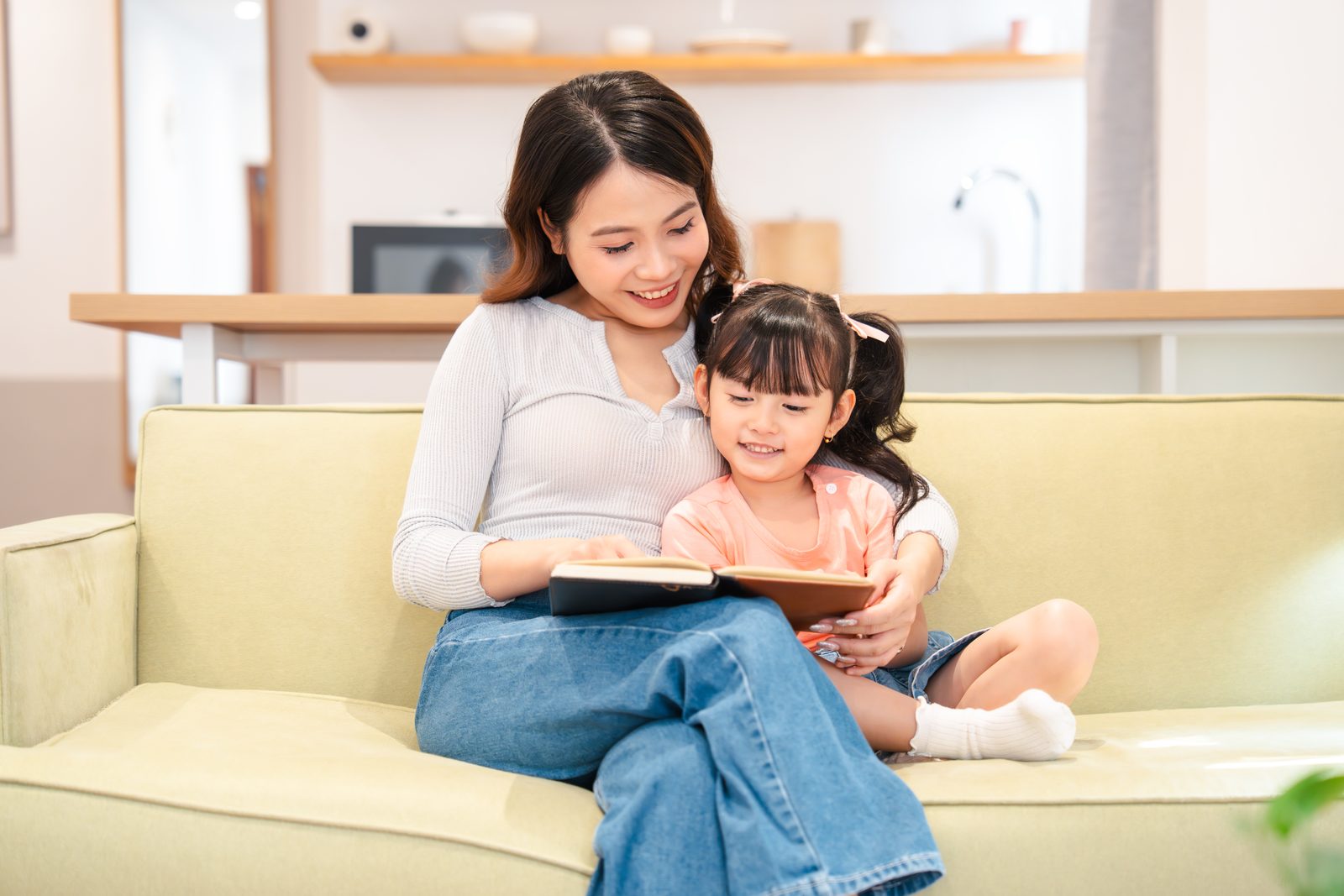 媽媽和女兒在沙發上一起讀故事書