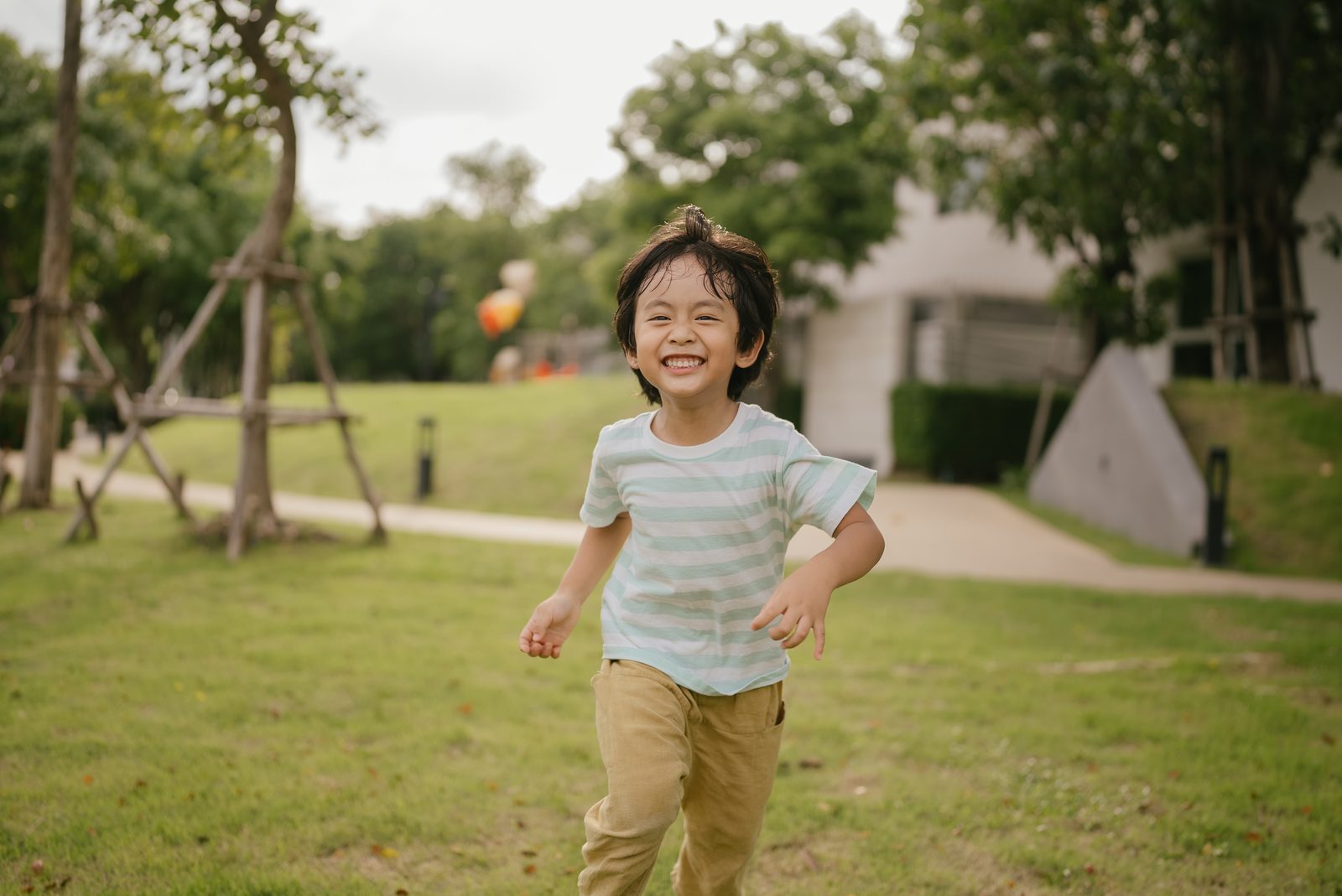 小男孩在公園草地上奔跑