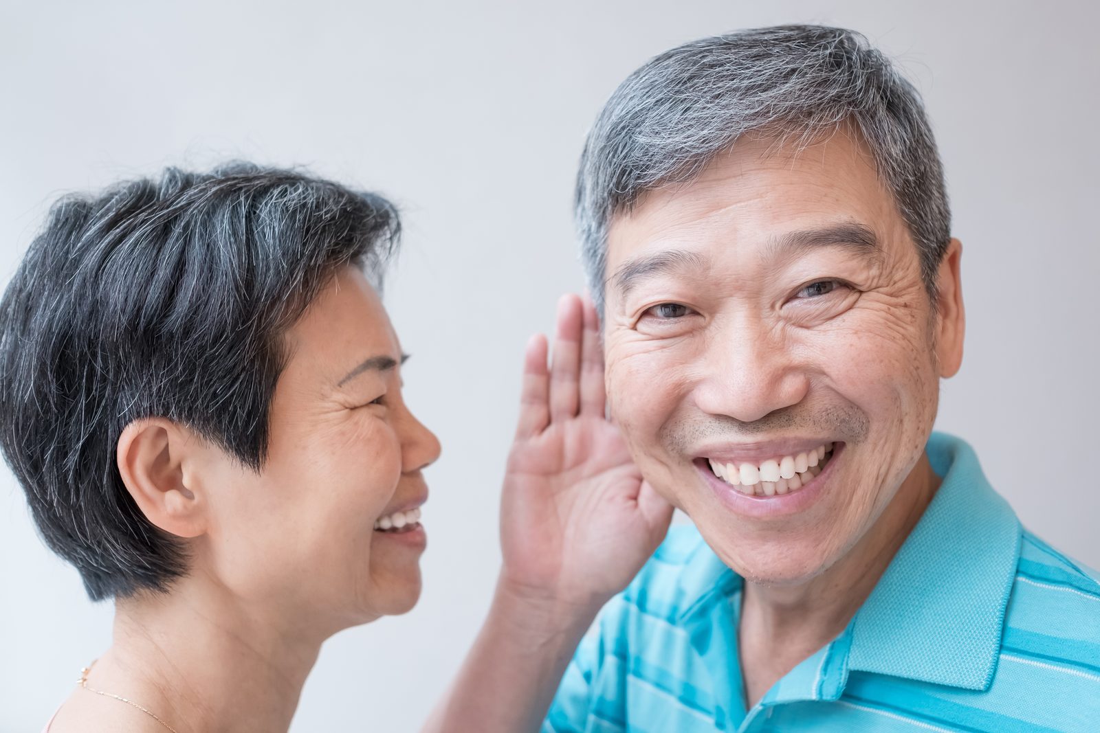 銀髮夫妻開心交談，先生手放耳邊聆聽