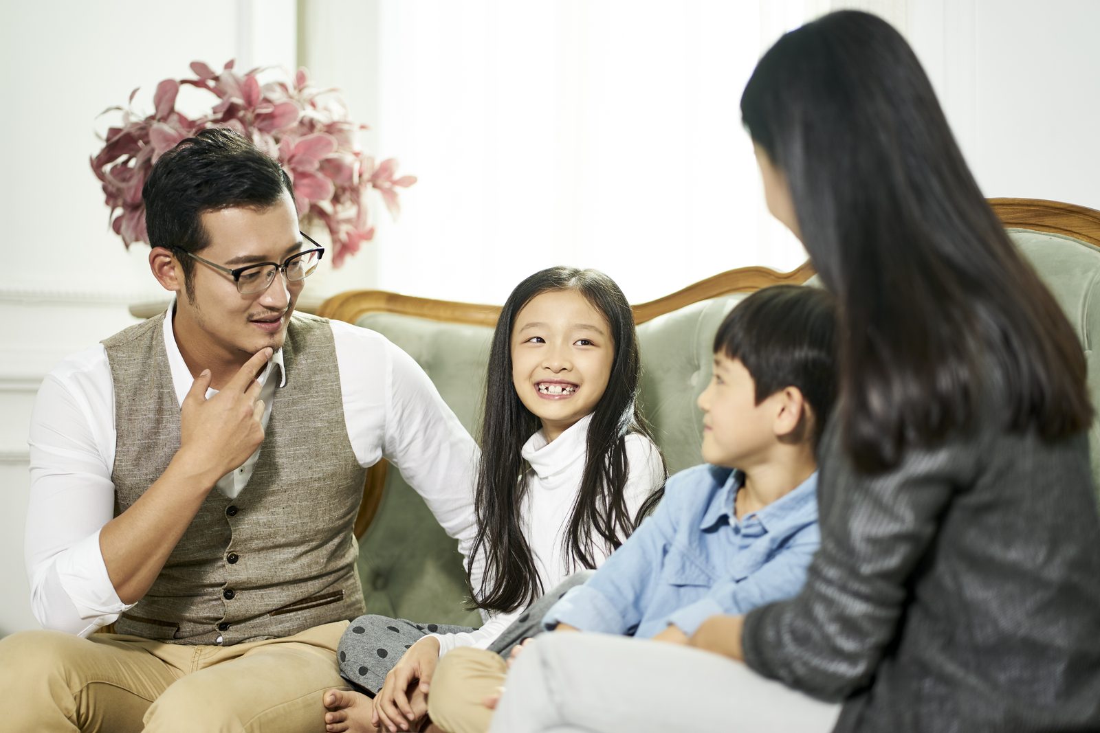 一家四口在客廳沙發上愉快聊天