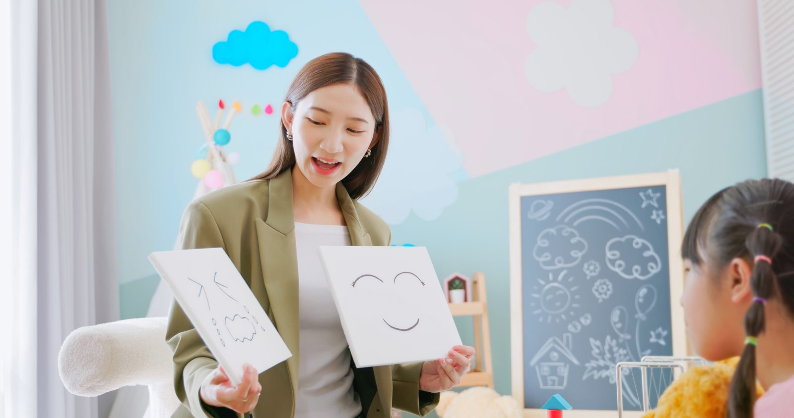 老師拿著表情圖卡為孩子上課
