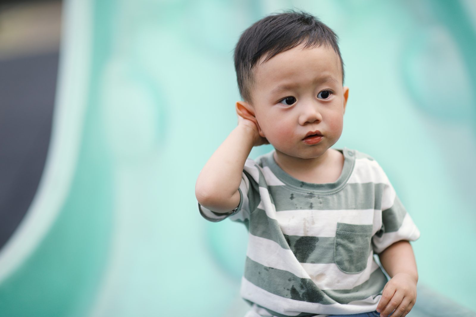 小男孩把手放在耳邊，好奇地聆聽