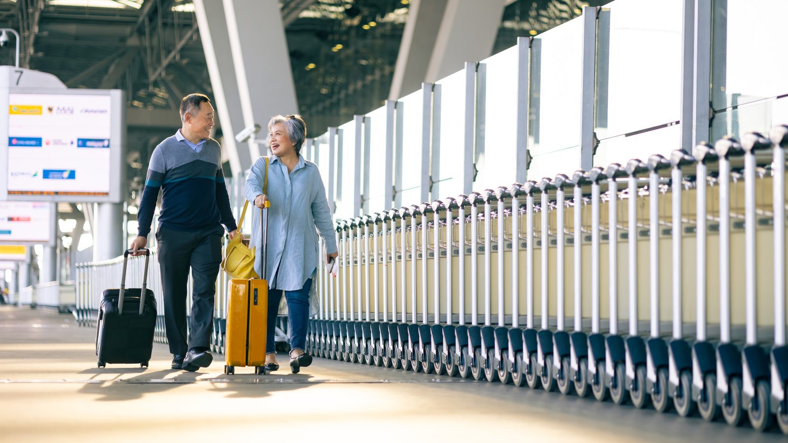 銀髮夫妻拉著行李走在機場航廈