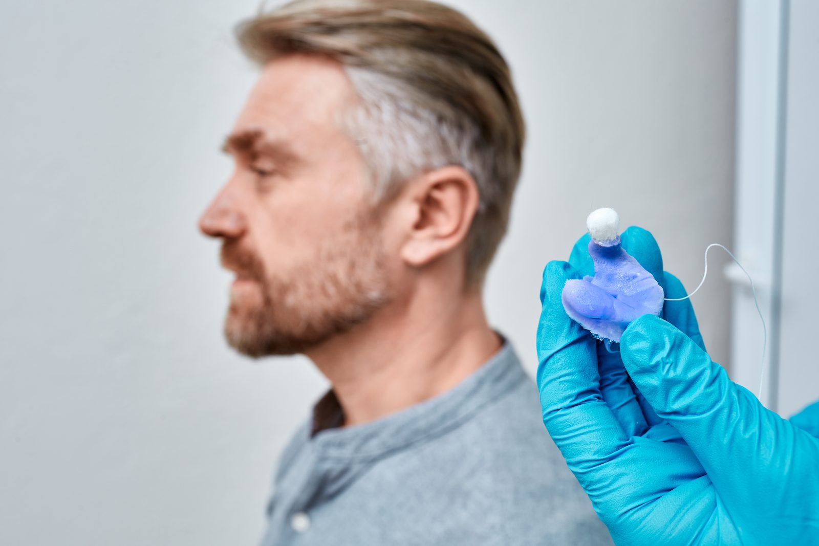 戴手套的聽力師手持客製耳模