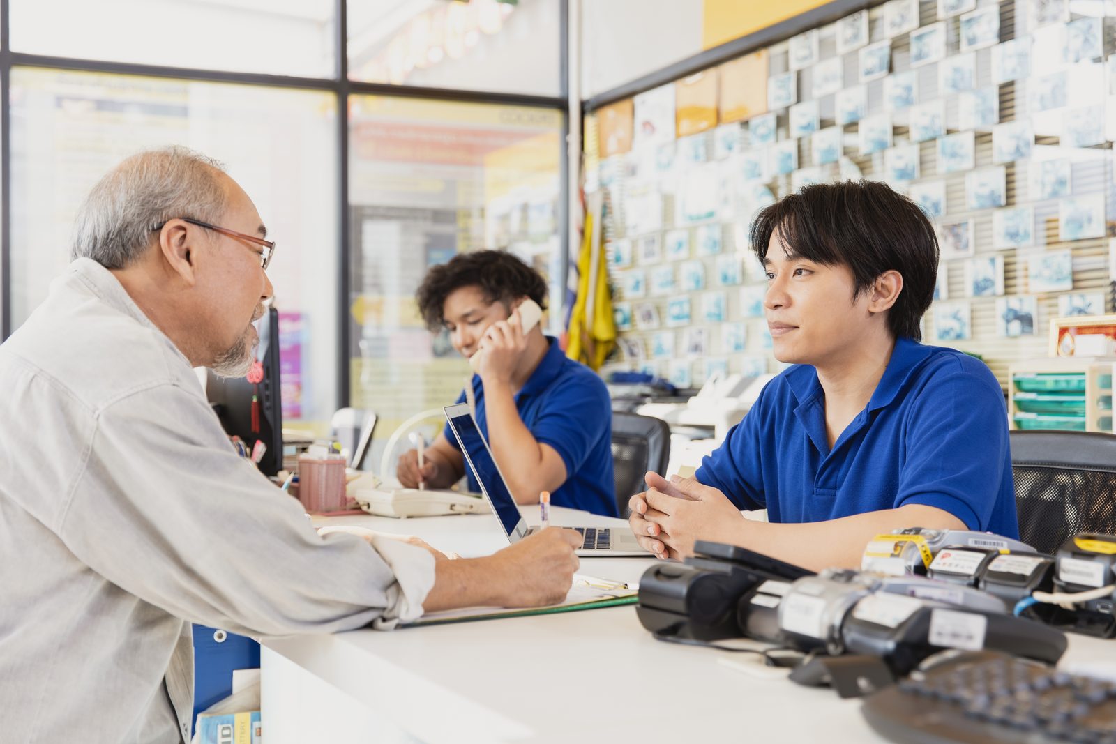 長輩在服務櫃檯與店員辦理文件
