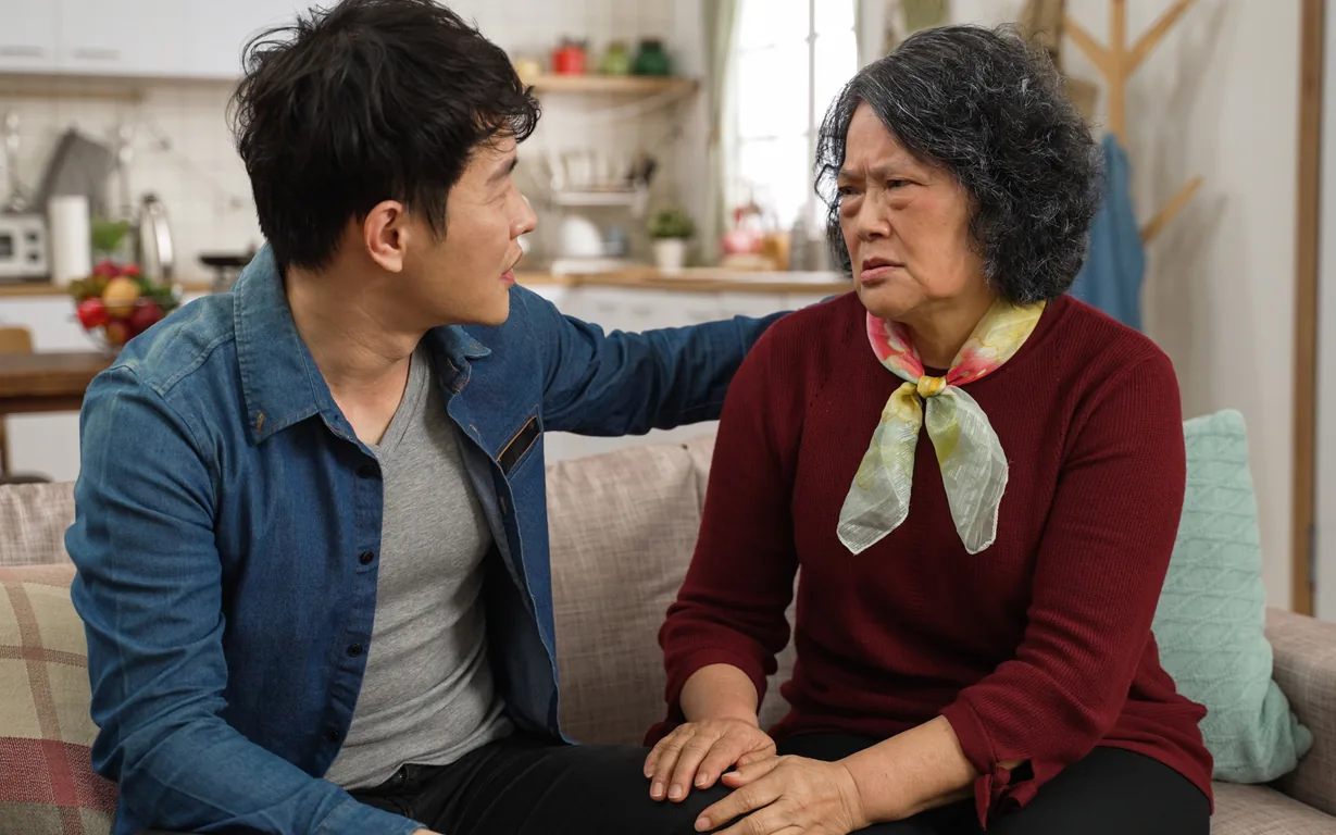 客廳沙發上，成年子女關切地與母親說話