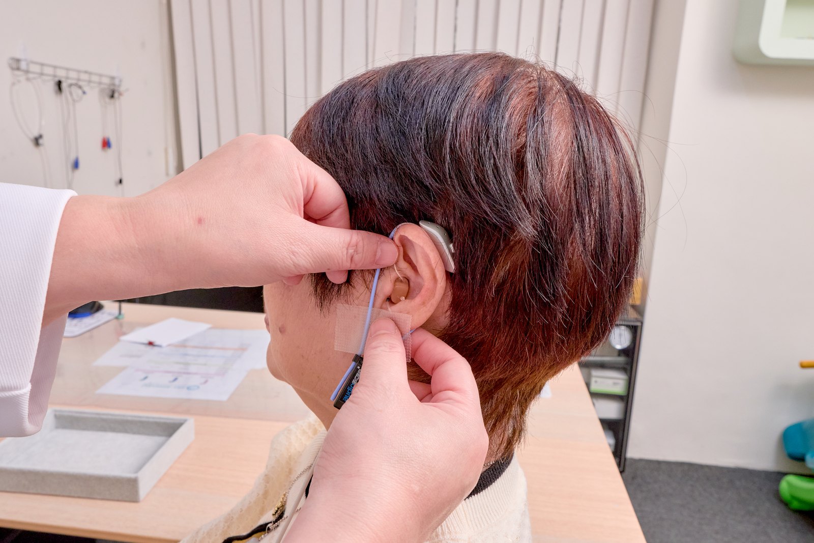 以法大聽力師將真耳測量探管放入配戴助聽器的耳道，進行 Real Ear Measurement 驗證