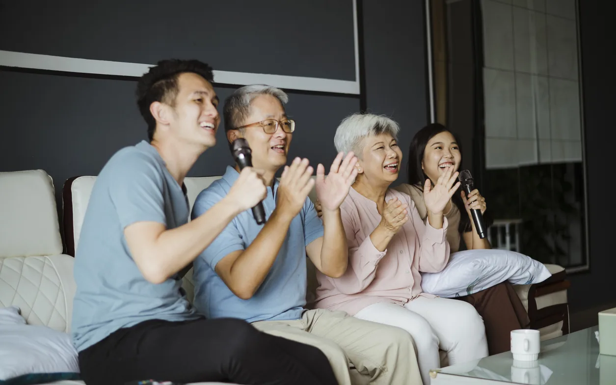 一家人在客廳唱卡拉 OK，長輩與子女一起同樂